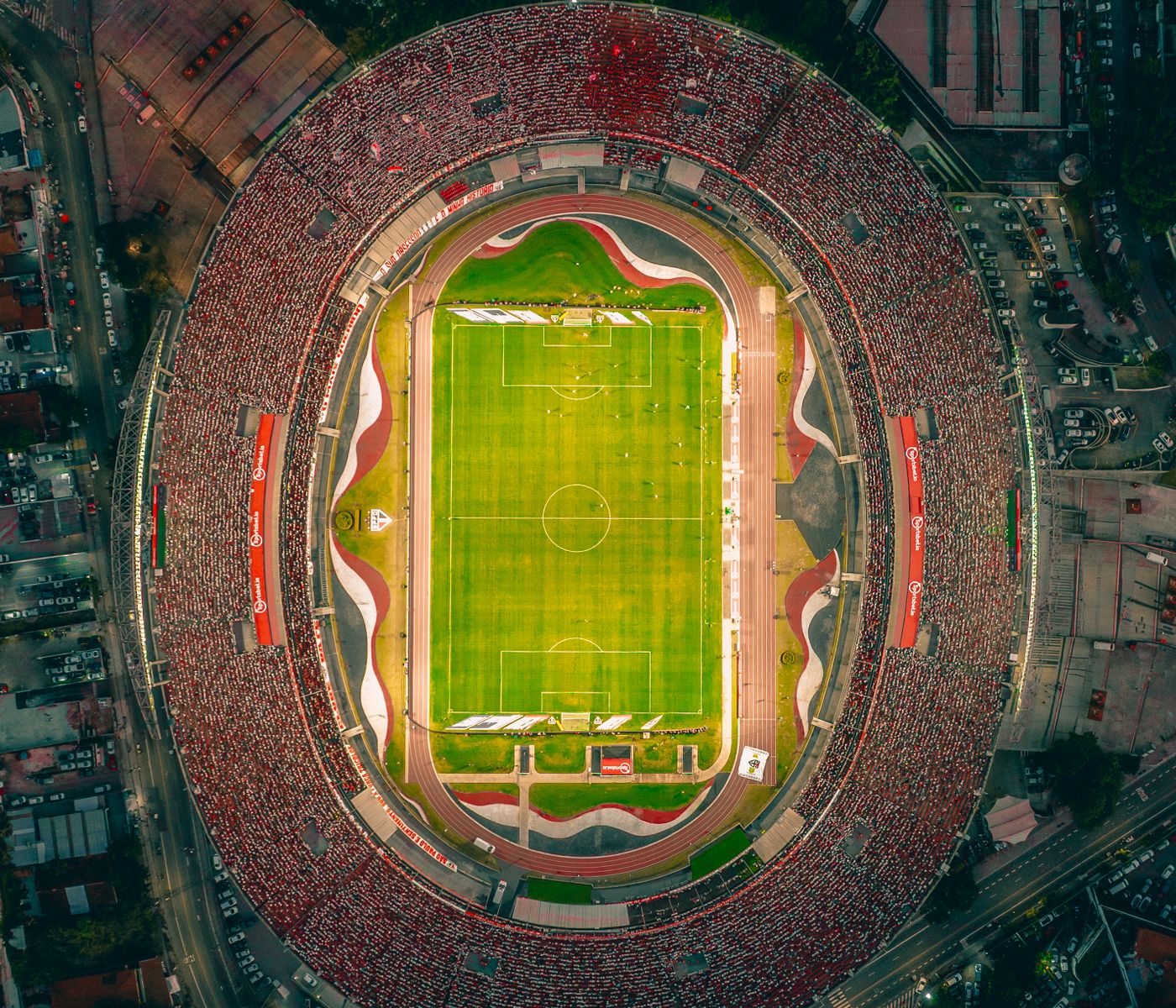 An aerial view of a packed stadium under floodlights at night